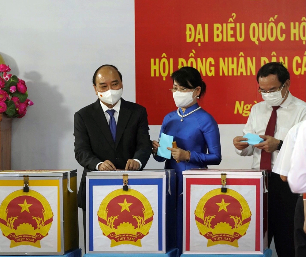 Chủ tịch nước Nguyễn Xuân Phúc cùng Phu nhân và Bí thư Thành ủy Thành phố Hồ Chí Minh Nguyễn Văn Nên cùng các cử tri bỏ phiếu bầu đại biểu Quốc hội khóa XV và Hội đồng nhân dân các cấp nhiệm kỳ 2021-2026. Ảnh: Trọng Hải